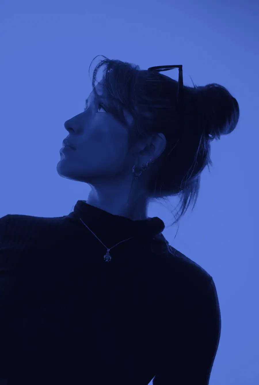 Nicole Aravena mirando hacia arriba, en tonos azules